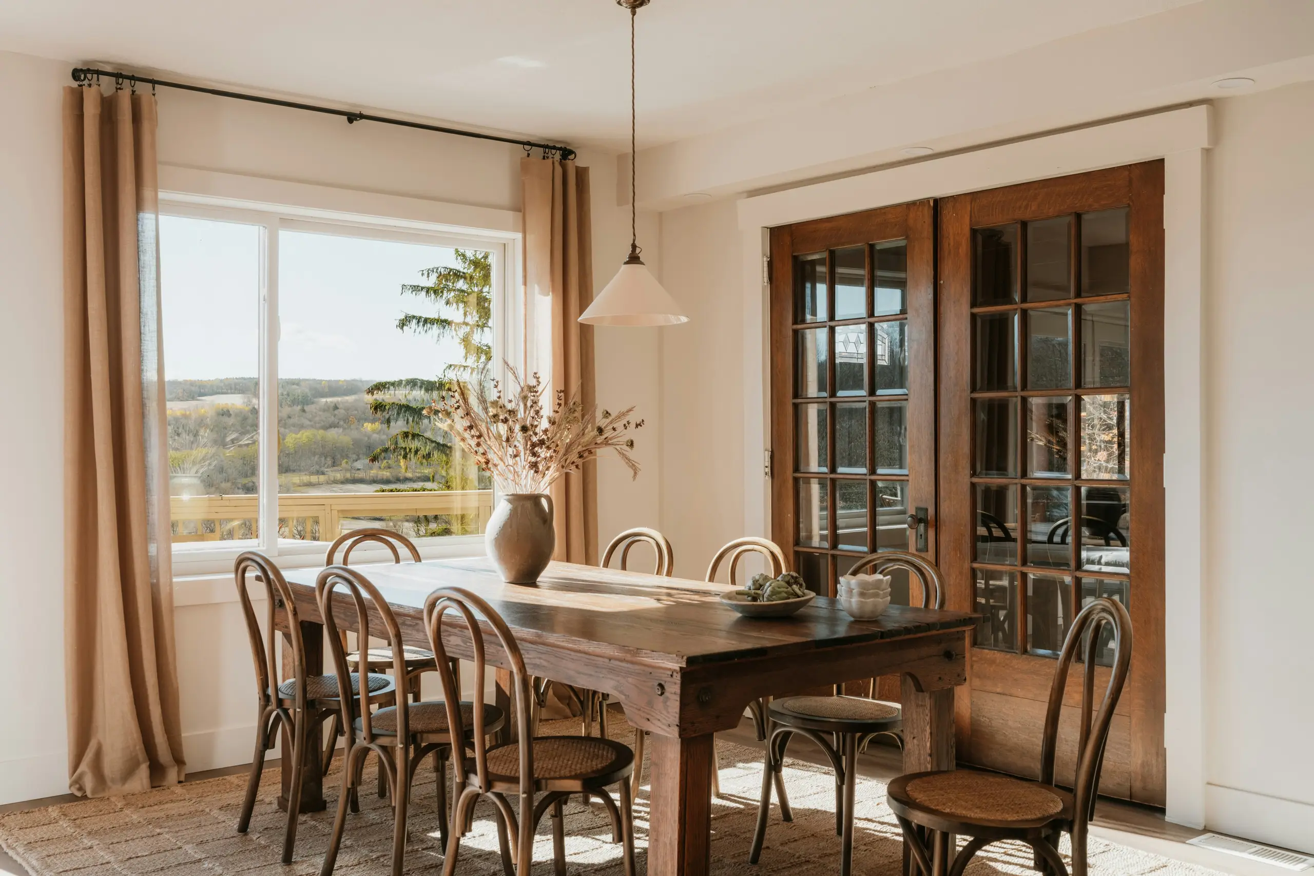 Sunlit dining room with a farmhouse table